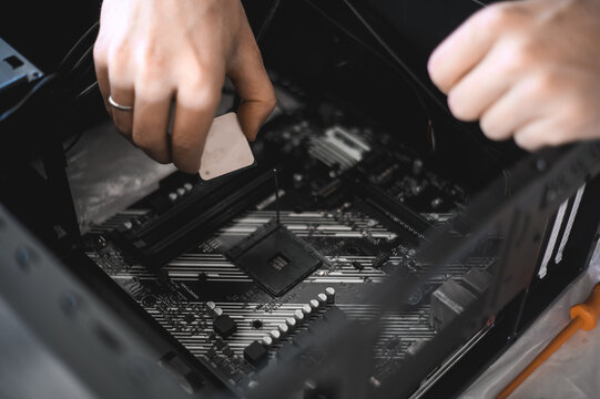 portrait of a handsome nerd man is servicing Computer motherboard and cooler.