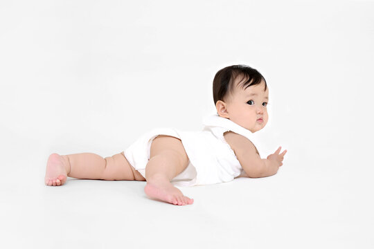 白背景でハイハイする女の子の赤ちゃん。元気,健康,成長,育児イメージ
