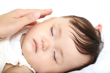 Fototapeta na wymiar 白背景で寝ている赤ちゃんの頬を優しく触れる母の手のクローズアップ。育児、愛情、母性イメージ