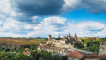 Fototapeta na wymiar Medieval Towers and fortress walls of Old Kamianets-Podilskyi Castle in Old Kamianets-Podilskyi town, Ukraine. Panoramic summer view of old famous Ukrainian Castle and picturesque nature landscape
