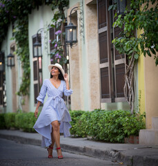 Smiling woman in the old town with a stripped dress and red heels
