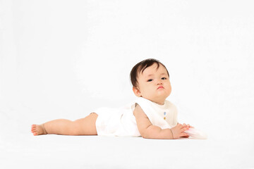 白背景でハイハイする女の子の赤ちゃん。元気,健康,成長,育児イメージ