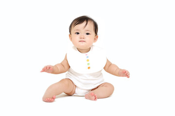 白背景で座り正面を向くカメラ目線の女の子の赤ちゃん
