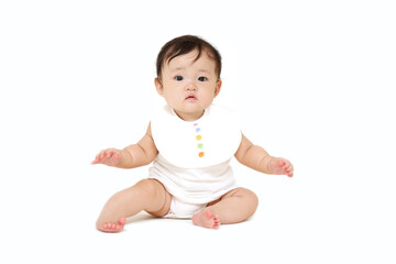 白背景で座り正面を向くカメラ目線の女の子の赤ちゃん