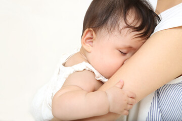 母の胸に抱かれ寝る赤ちゃん。愛情、育児、愛情、母性イメージ