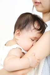 母の胸に抱かれ寝る赤ちゃん。愛情、育児、愛情、母性イメージ