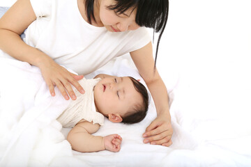 寝ている赤ちゃんに優しく手で触れる母さん。育児、母子、愛情イメージ