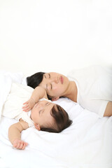 Fototapeta na wymiar 新生児と一緒に昼寝するお母さん。育児疲れイメージ