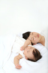 Fototapeta na wymiar 新生児と一緒に昼寝するお母さん。育児疲れイメージ