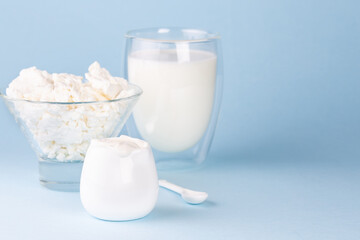 Glass of milk, cottage cheese and sour cream on a blue