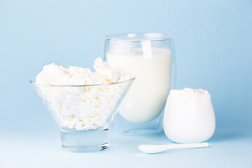 Glass of milk, cottage cheese and sour cream on a blue