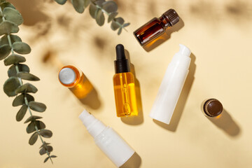 A set of cosmetics for summer face and body care on a beige background with hard shadows. Natural organic cosmetics