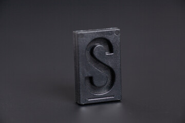 Letter Press S on black background