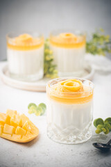 Italian dessert panna cotta with mango in glass on white background