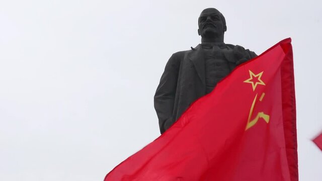 Monument to Vladimir Lenin end soviet flag flying.