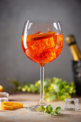 Aperol spritz cocktail in glass with fresh orange on gray background