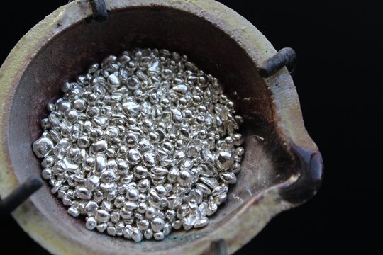 A ceramic crucible or melting pot with grains of sterling silver 925 for jewelry making after hand smelting in a workshop. One of the two major precious metals on the market.