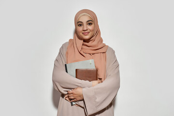 Happy young arabic business woman in hijab with notepad