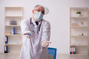 Fototapeta premium Old male doctor in vaccination concept