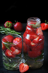 Refreshing mineral water drink with strawberries and rosemary. Detox drinks. Diet concept.