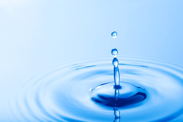 Drop of water. Water droplet falling impact with water surface. causing rings on water surface..