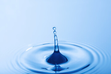 Drop of water. Water droplet falling impact with water surface. causing rings on water surface..