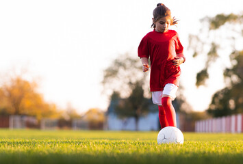 Little girl kicks soccer ball