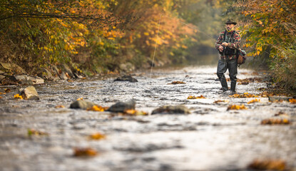 Fly fisherman fly fishing on a splendid mountain river - Powered by Adobe