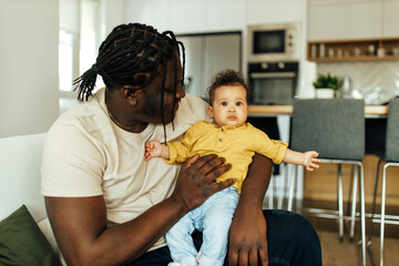 Loving father and baby daughter at home relaxing.