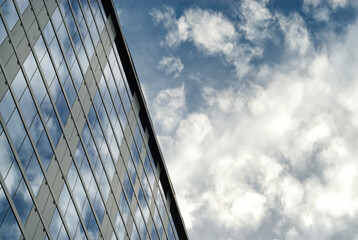 Fototapeta na wymiar Cloudy sky reflected in a glassy building/