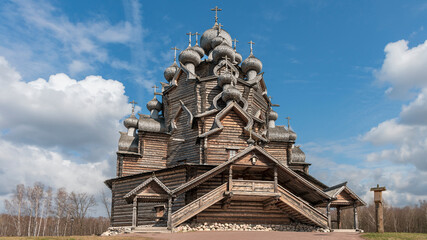 Old historic wooden church in the suburbs of the Russian city of St. Petersburg against the background of a blue cloudy sky