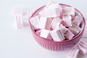 marshmallow in a pink bowl close-up. background with marmalade in a bowl on a white background.