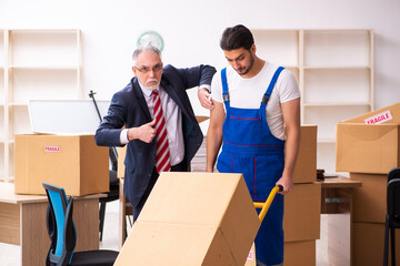 Old businessman and young contractor in relocation concept