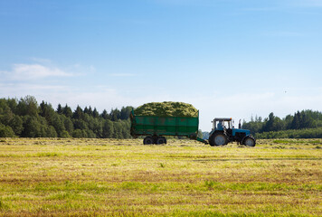 Tractor with a trailer in the field for agricultural work. 