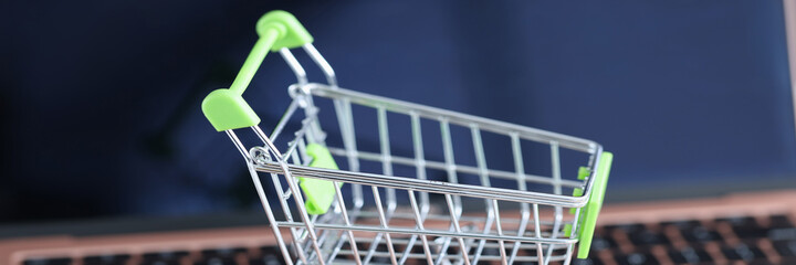 Shopping basket on the laptop keyboard closeup