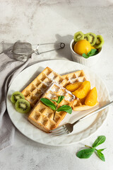 Fresh Belgian waffles with fruits served for breakfast