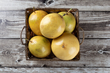 Passion fruit in a basket on wooden table top view