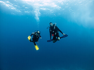 Tow divers underwater.