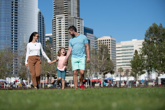 Happy American Family With Little Child Son Walking In Modern Urban City.