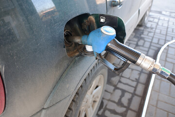 refueling a dark green jeep at a gas station, the pestolet is inserted into the tank. gasoline price rise concept.