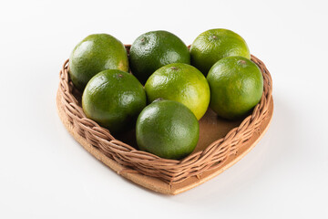 Ripe green lemon fruit in basket with heart shape