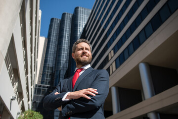 Entrepreneur, business portrait. Businessman standing proud with arms crossed outside.