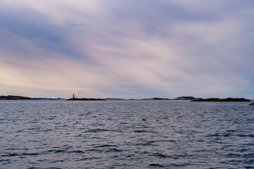 Obraz premium A picture of a beautiful rock island. Ocean and blue sky with thin clouds in the background. Picture from the the Weather Islands, on the Swedish West coast