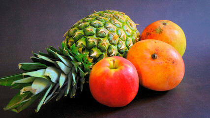Pineapple, apple and mango, Colorful fruits in dark background. Juicy fruits background. Healthy eating, Fruit juice shop. 
