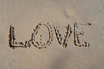 LOVE inscription on summer sandy beach. Relation ship and togetherness concept 