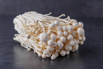 Fresh Enoki mushrooms on black background with selected focus.Enoki, also known as velvet shank, is a species of edible mushroom in the family Physalacriaceae.
