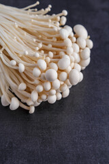 Fresh Enoki mushrooms on black background with selected focus.Enoki, also known as velvet shank, is a species of edible mushroom in the family Physalacriaceae.