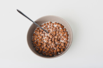 Breakfast crunchy chocolate balls with milk on white background