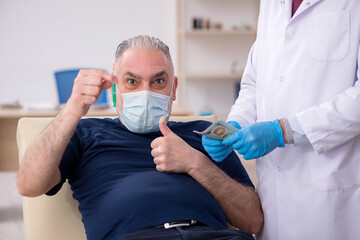 Old male patient visiting young male doctor in vaccination conce