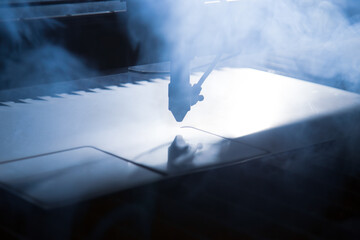 Closeup detail view of a laser cutter during a steel layer shaping process